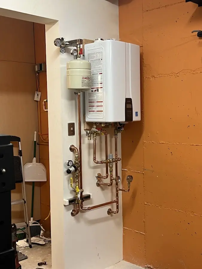 Plumbing technician inspecting water heater connections in Reserve